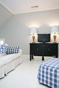 Living room with white painted floor and blue plaid ottoman